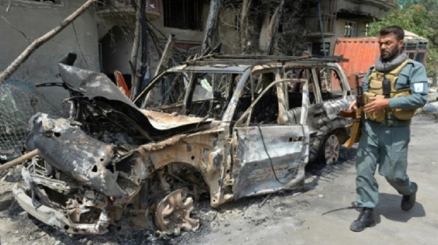 a member of the afghan security forces walks past the site of an attack in kabul this week photo afp