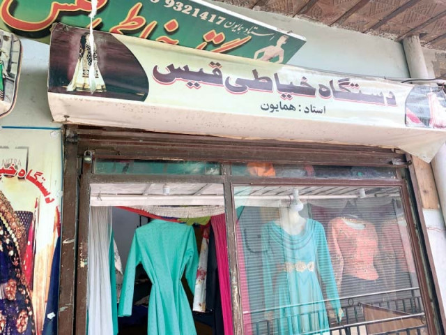 a sign board in persian on a dress shop owned by an afghan refugee photo express