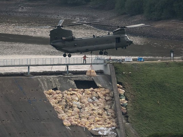 an raf chinook helicopter drops more bags of aggregate on the damaged section of spillway of the toddbrook reservoir dam above the town of whaley bridge in northern england on august 4 2019 photo afp