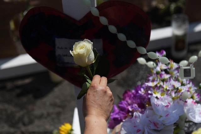 a woman places a rose on a cross as people gather to pay their respects at a growing memorial site two days after a mass shooting at a walmart store in el paso texas us august 5 2019 photo reuters