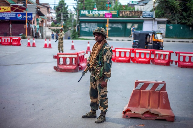 in this picture taken on august 6 2019 security personnel stand guard on a street in srinagar photo afp