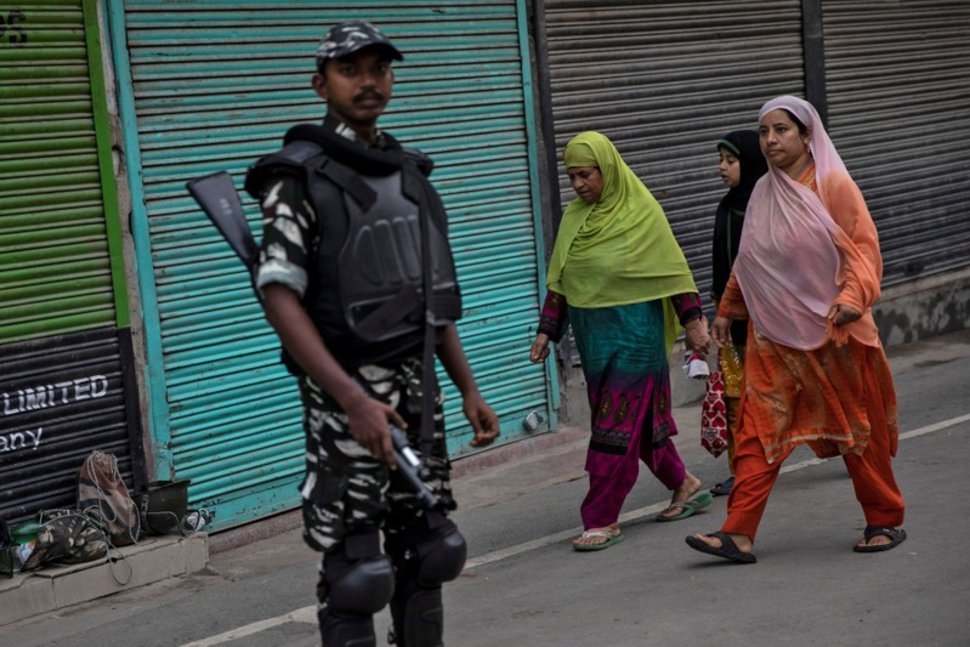 kashmiri women walk past an indian security personnel during restrictions after the scrapping of the special constitutional status photo reuters