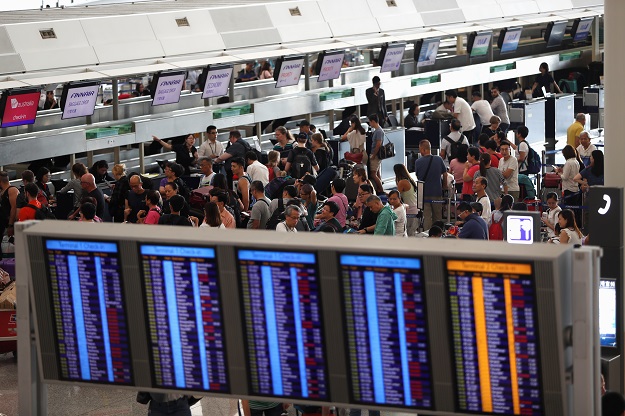 passengers queue at check in counters as the airport reopened a day after flights were halted due to a protest at hong kong international airport china photo reuters