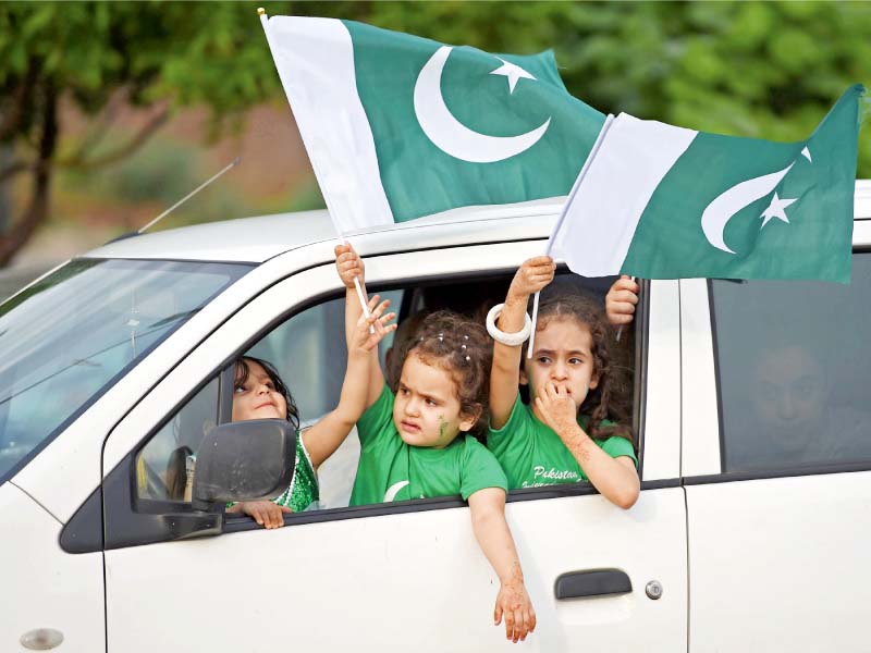 children wave national flags as people take part in an independence day rally in islamabad photos afp express