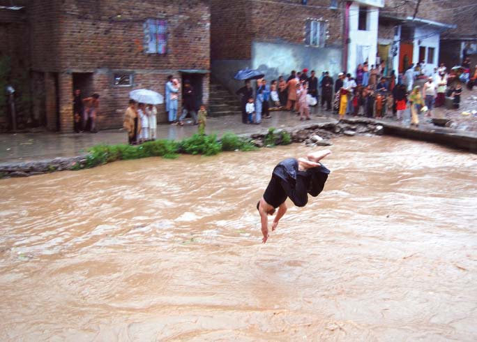 a boy takes a dip in nullah leh after heavy monsoon showers in july photo file express