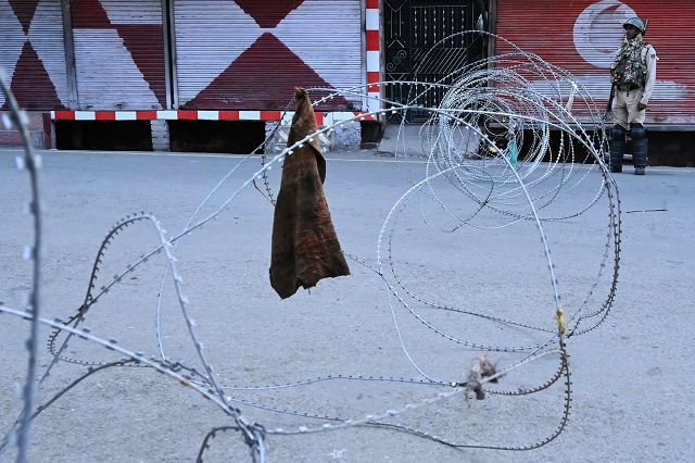 a security personnel stands guard on a street during a lockdown in srinagar on august 12 2019 photo afp