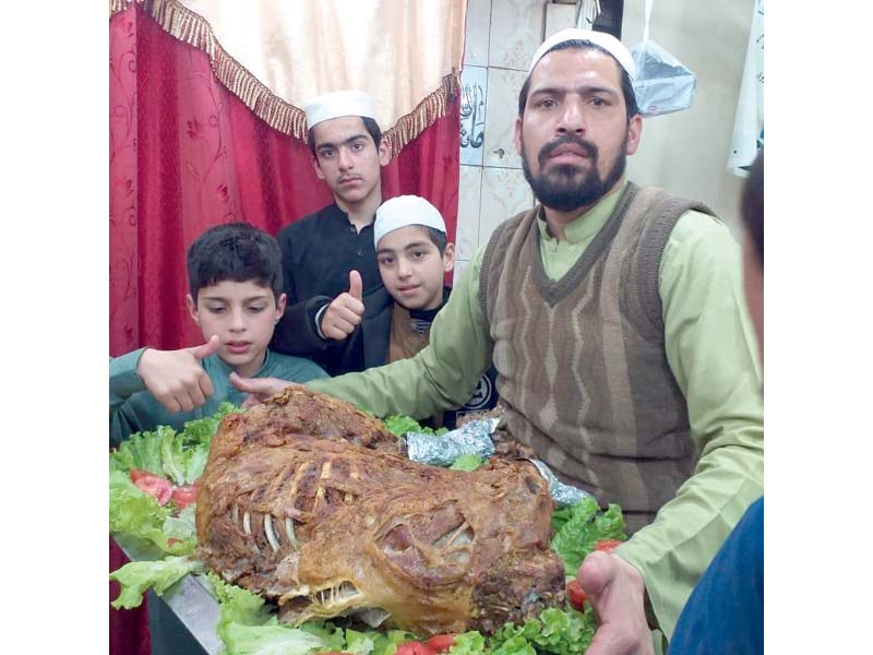 a chef flaunts his roasted lamb as workers prepare a lamb for roasting arab style photos express