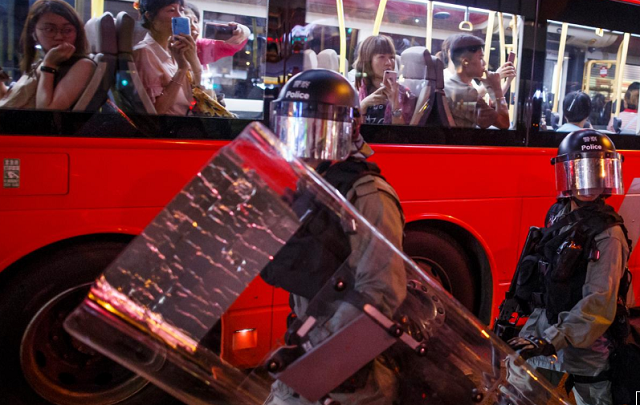 passengers on a city bus watch riot police chase anti government protesters down nathan road in mong kok in hong kong china photo reuters
