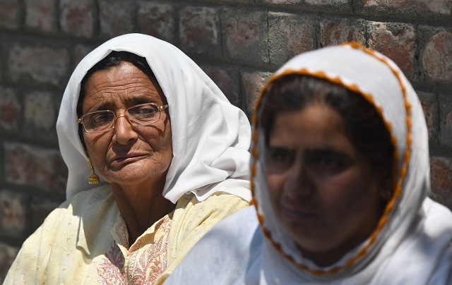 kashmiri women wait outside a police station after their relative was detained during night raids in srinagar on august 20 2019 photo afp