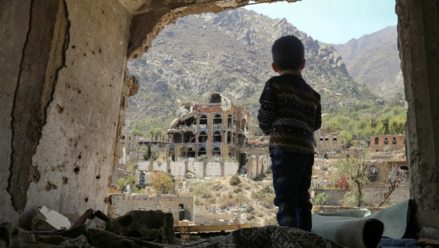 a photo taken on march 18 2018 shows a yemeni child looking out at buildings that were damaged in an air strike in the southern yemeni city of taez photo afp