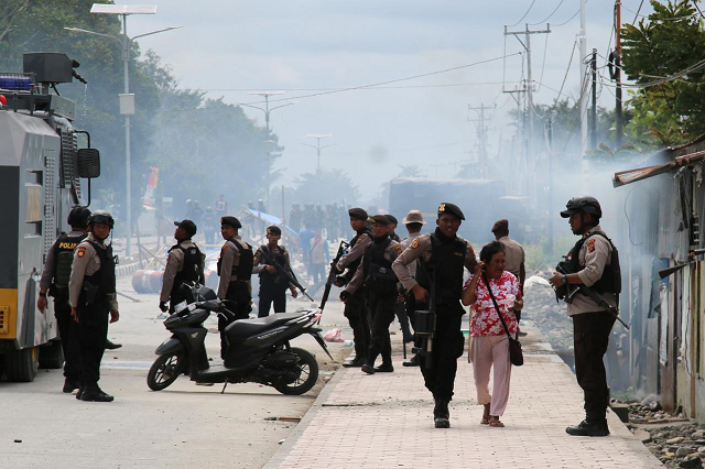 a police officer escorts a woman during a protest in mimika papua indonesia august 21 2019 photo reuters a police officer escorts a woman during a protest in mimika papua indonesia august 21 2019 photo reuters