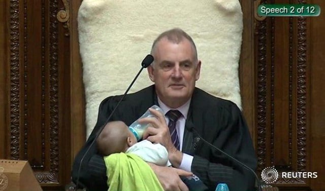 speaker of new zealand s parliament trevor mallard feeds a lawmaker 039 s baby with a bottle during a parliament session photo reuters