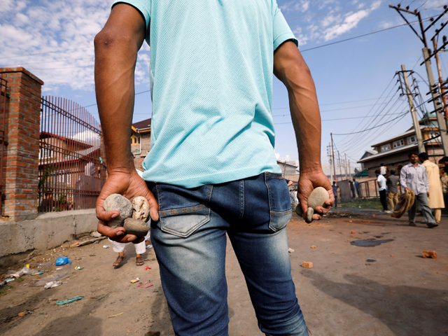 a kashmiri man holds stones during clashes with indian security forces in srinagar august 23 2019 photo reuters