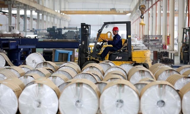 a worker drives a forklift past aluminum rolls at a factory in huaibei anhui province china march 2 2019 photo reuters stringer