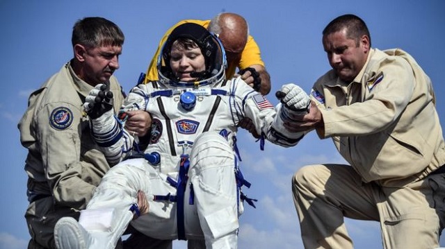anne mcclain is helped from a space capsule after returning from the iss in june photo reuters