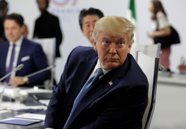 president donald trump looks around as photographers take photos ahead of a working session on world economy and trade on the second day of the g 7 summit in biarritz photo reuters