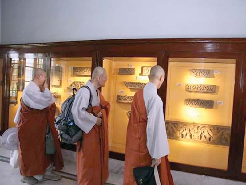 buddhist monks from korea react to gandhara relics at the peshawar museum on monday photo express