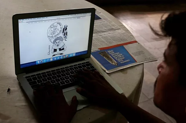 a man reads a newspaper 039 s website with a cartoon depicting an alien creature on a computer screen at a library in karachi pakistan june 5 2018 photo reuters a man reads a newspaper 039 s website with a cartoon depicting an alien creature on a computer screen at a library in karachi pakistan june 5 2018 photo reuters