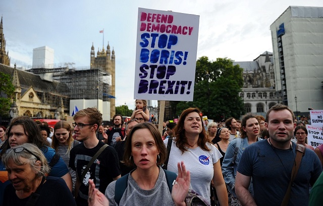 anti brexit demonstrators hold placards as they take part in a protest march from britain 039 s houses of parliament to downing street in london photo afp