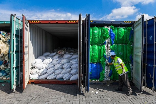 a malaysian official inspects containers filled with plastic waste in port klang west of kuala lumpur in may 2019 photo afp