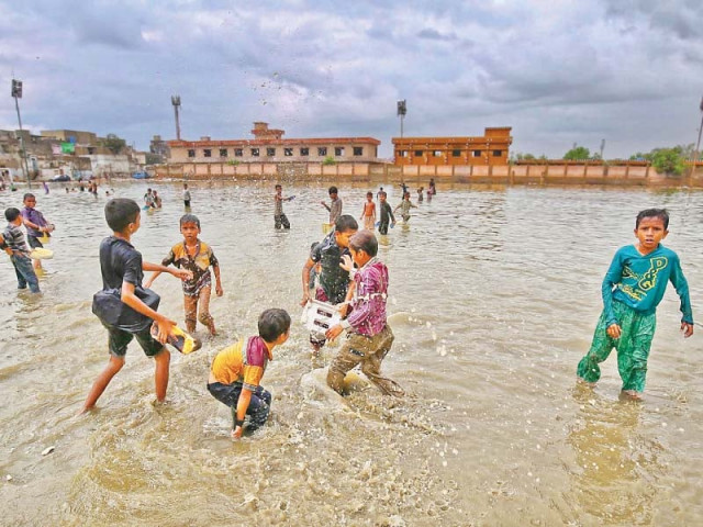 children play in a pool of water that was formed after the recent spell of rain that started on wednesday the met department has forecast heavy and moderate rain in different parts of the city today photo inp