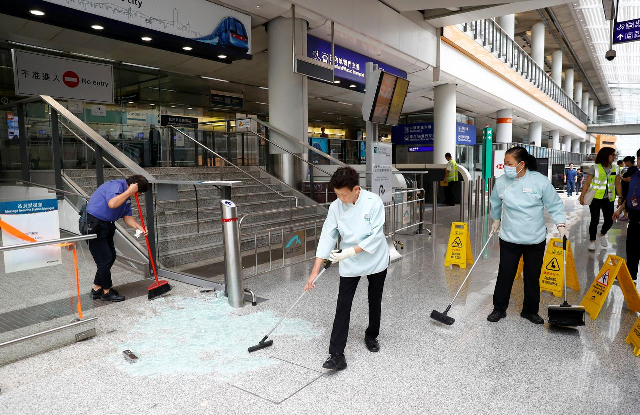 staff clean up glass from a glass door broken by protesters inside hong kong international airport photo reuters staff clean up glass from a glass door broken by protesters inside hong kong international airport photo reuters