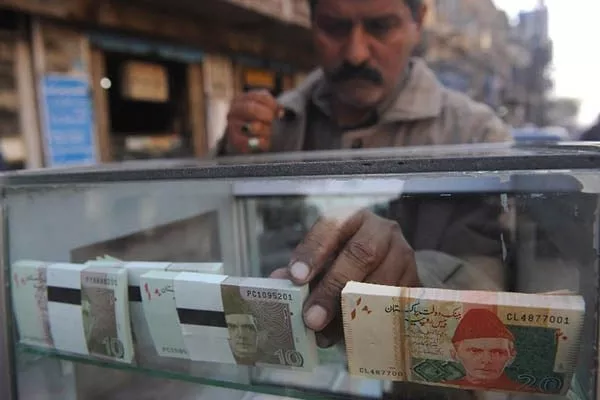 a vendor arranges 10 and 20 rupee pakistani bank notes in a display shelf at a commercial area in karachi photo afp a vendor arranges 10 and 20 rupee pakistani bank notes in a display shelf at a commercial area in karachi photo afp