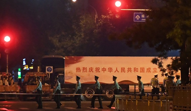 chinese paramilitary police march past trucks with propaganda slogans on beijing 039 s main east west boulevard during an overnight rehearsal for a military parade to mark communist china 039 s 70th anniversary photo afp