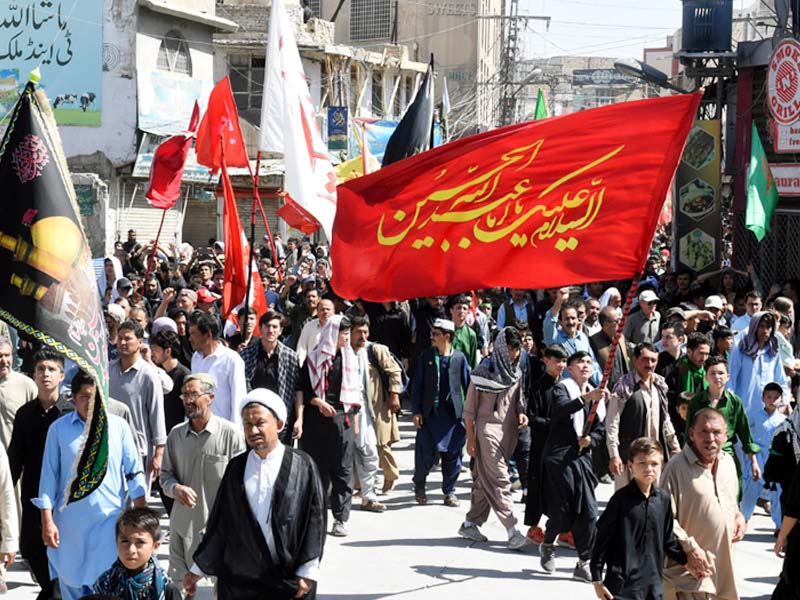 mourners hold religious flags as they march during a procession on the tenth day of muharram in quetta photo afp