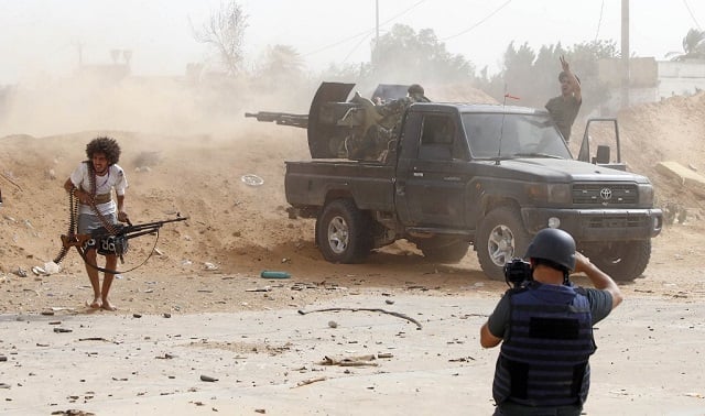 a journalist covers the frontline during clashes between forces loyal to strongman khalifa haftar and fighters loyal to the libyan internationally recognized government of national accord gna south of the libyan capital tripoli photo afp