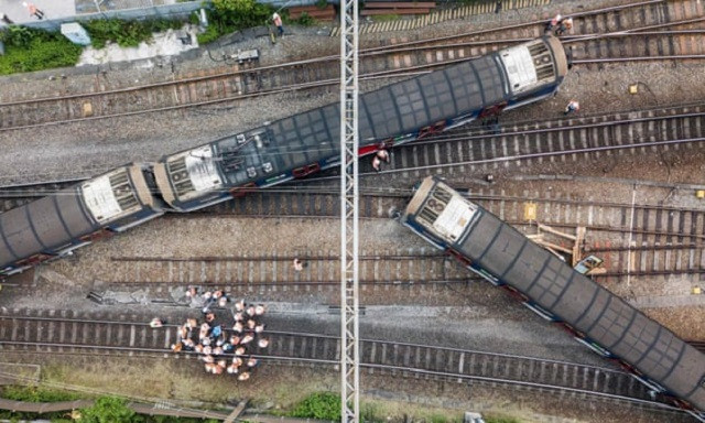 rescue workers stand near a passenger train after it derailed during rush hour outside hung hom station on the kowloon side of hong kong photo afp rescue workers stand near a passenger train after it derailed during rush hour outside hung hom station on the kowloon side of hong kong photo afp