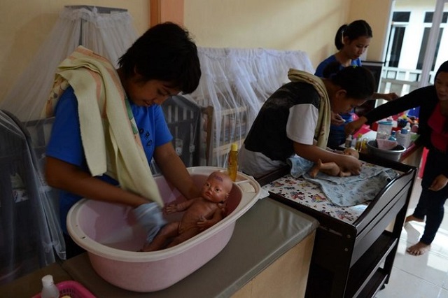 in this photo indonesian maids undergo training in jakarta for infant care prior to their deployment about 250 000 domestic helpers from other parts of asia work in affluent singapore photo afp