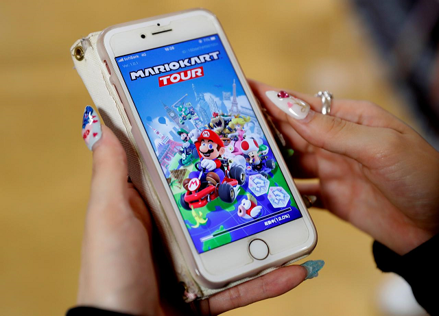 a woman shows the mobile title mario kart tour on her smartphone during an interview with reuters at tatio 039 s game center in tokyo japan september 25 2019 photo reuters