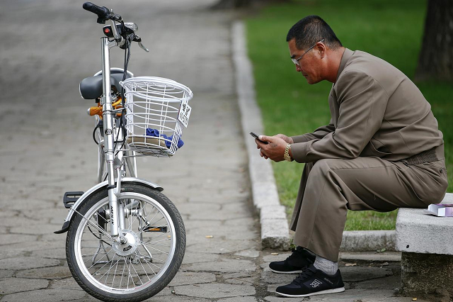 a man uses his mobile phone next to an electric bicycle in downtown pyongyang north korea october 8 2015 photo reuters a man uses his mobile phone next to an electric bicycle in downtown pyongyang north korea october 8 2015 photo reuters