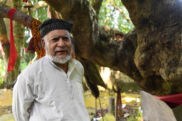 muslim caretaker motibar rahman 73 standing by a shrine to the hindu deity shiva photo afp