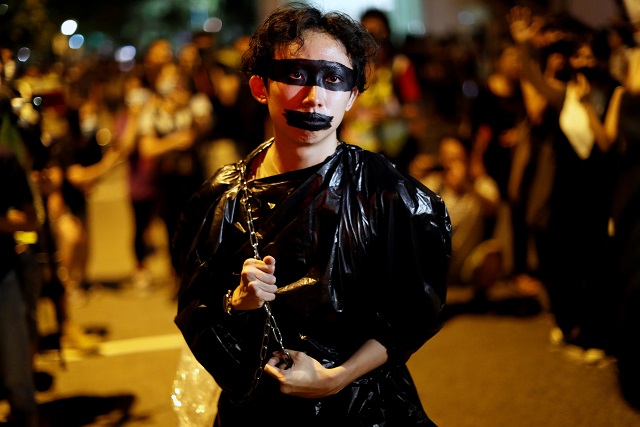 a performer carries a chain outside the venue of first community dialogue held by hong kong chief executive carrie lam photo reuters