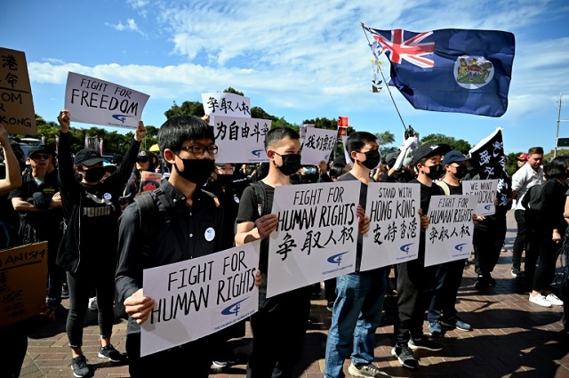 supporters of the hong kong pro democracy protesters hold placards during a demonstration as part of the global quot anti totalitarianism quot movement in sydney photo afp