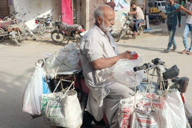 everyday javed hauls his three wheeled bike and delivers plastic bags to shopkeepers in karachi photo express everyday javed hauls his three wheeled bike and delivers plastic bags to shopkeepers in karachi photo express
