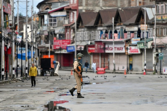 an indian security personnel patrols a deserted street in indian occupied kashmir photo afp an indian security personnel patrols a deserted street in indian occupied kashmir photo afp