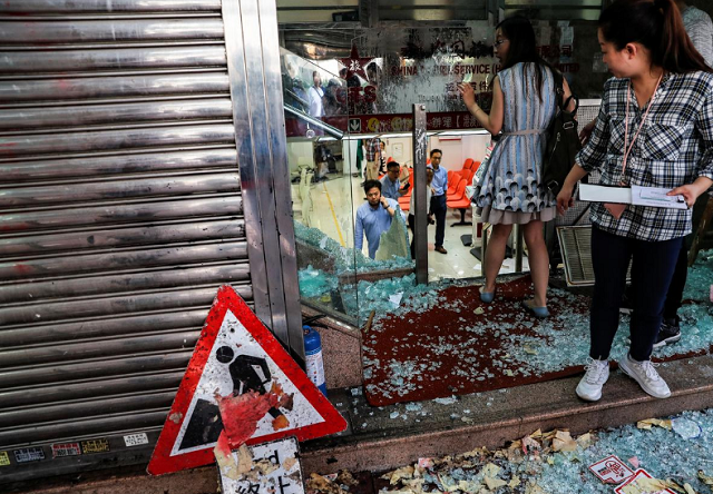 employees of china travel service a tourism and travel agency of the china government are seen at their vandalized office in tsuen wan hong kong china photo reuters