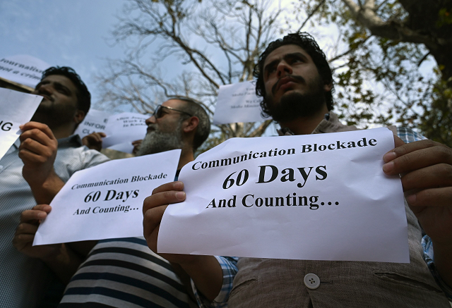 journalists hold signs during a protest against the ongoing restrictions of the internet and mobile phone networks at the kashmir press club during a lockdown in srinagar on october 3 2019 photo afp