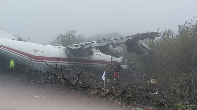 this handout photograph taken and released by the ukrainian emergency ministry shows rescuers as they work at the plane crash site in a forest outside lviv on october 4 2019 photo afp