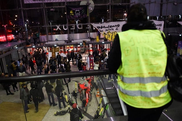 a yellow vest stands as protestors stay inside the italie deux shopping mall in paris during a demonstration called by the extinction rebellion environmental activist movement photo afp a yellow vest stands as protestors stay inside the italie deux shopping mall in paris during a demonstration called by the extinction rebellion environmental activist movement photo afp