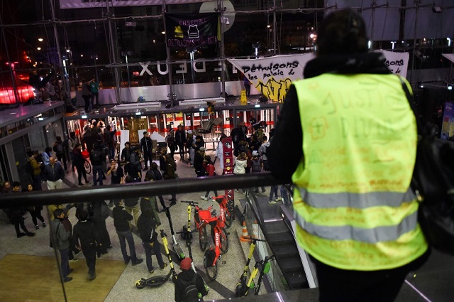 a yellow vest stands as protestors stay inside the italie deux shopping mall in paris during a demonstration called by the extinction rebellion environmental activist movement photo afp