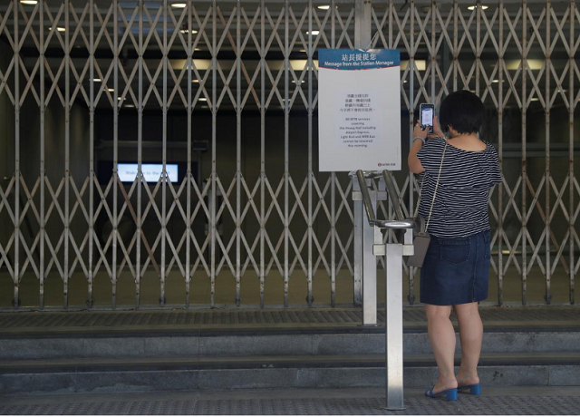 a woman takes a picture of an information board at the suspended metro station in tsim sha tsui district in hong kong china photo reuters a woman takes a picture of an information board at the suspended metro station in tsim sha tsui district in hong kong china photo reuters