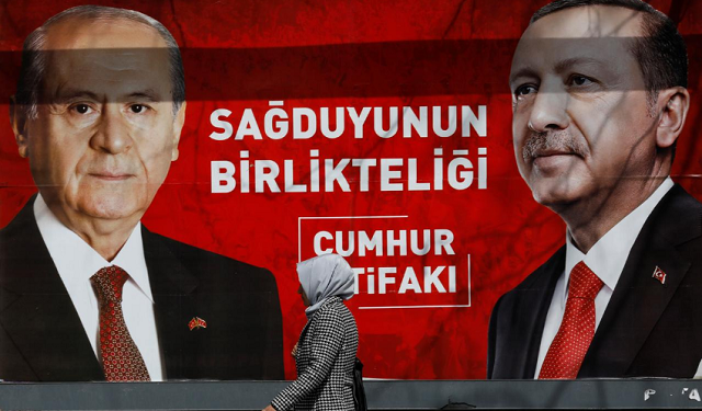 a woman walks past a banner for the upcoming local elections in ankara turkey march 27 2019 banner with pictures of turkish president tayyip erdogan and devlet bahceli leader of nationalist movement party mhp reads quot people 039 s alliance the unity of common sense quot photo reuters