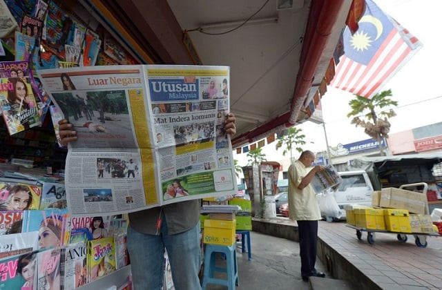 a malaysian man reads a newspaper outside a shop in downtown kuala lumpur on october 10 2012 photo afp a malaysian man reads a newspaper outside a shop in downtown kuala lumpur on october 10 2012 photo afp