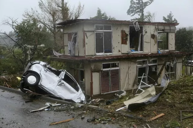 a vehicle lies in a ditch next to a badly damaged house in chiba prefecture east of tokyo after strong winds brought by typhoon hagibis hit the area photo afp a vehicle lies in a ditch next to a badly damaged house in chiba prefecture east of tokyo after strong winds brought by typhoon hagibis hit the area photo afp