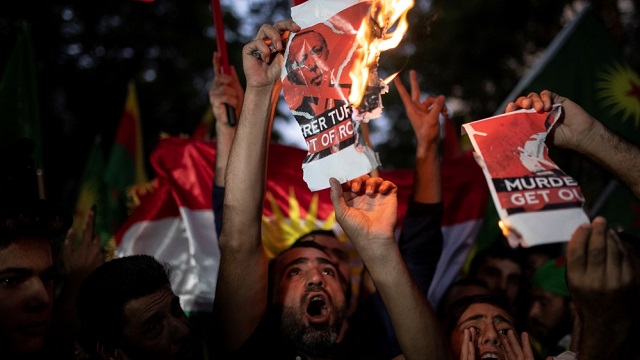 kurds living in greece shout slogans while burning a poster depicting turkish president tayyip erdogan during a demonstration against turkey 039 s military action in northeastern syria in athens greece photo reuters file