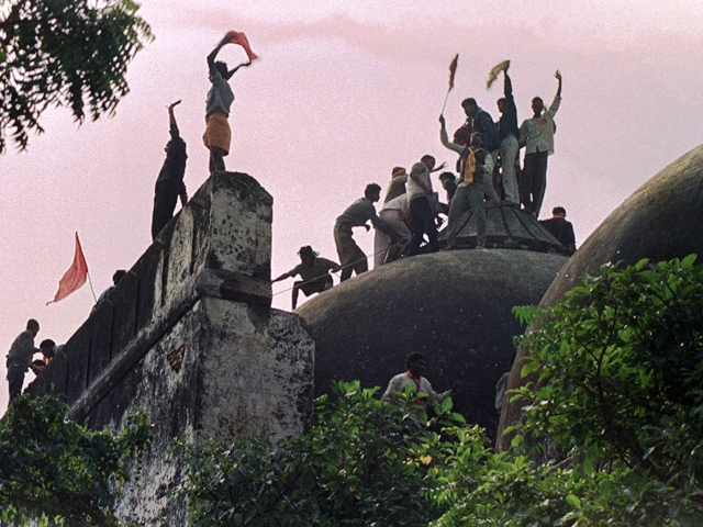 a file photo taken on december 6 1992 shows hindu fundamentalists shouting and waving banners as they stand on the top of a stone wall and celebrate the destruction of the 16th century babri mosque in ayodhya photo afp